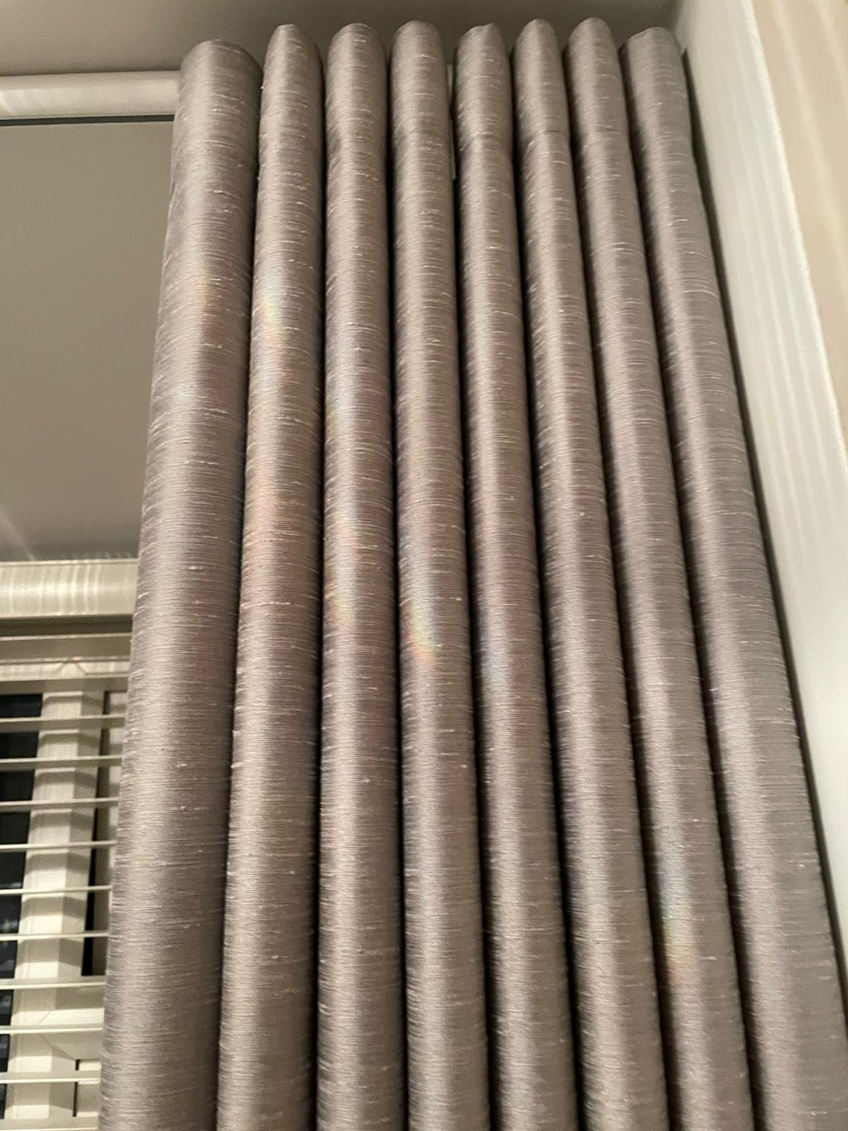 A close up of a row of curtains hanging on a window.