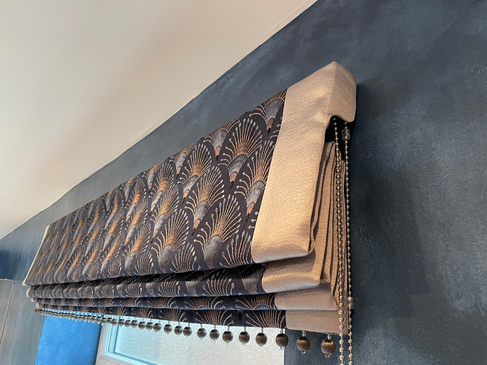 A close up of a roman shade on a window.