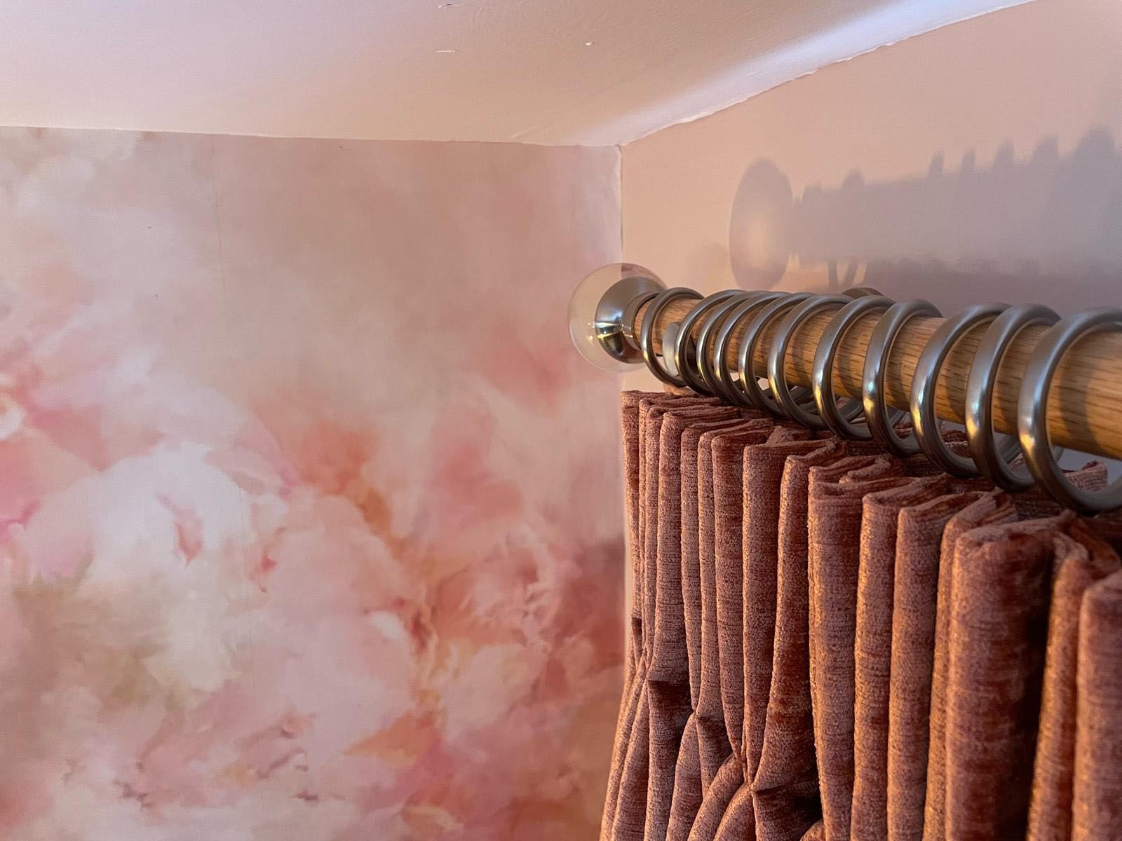 A close up of a pair of curtains hanging on a curtain rod.