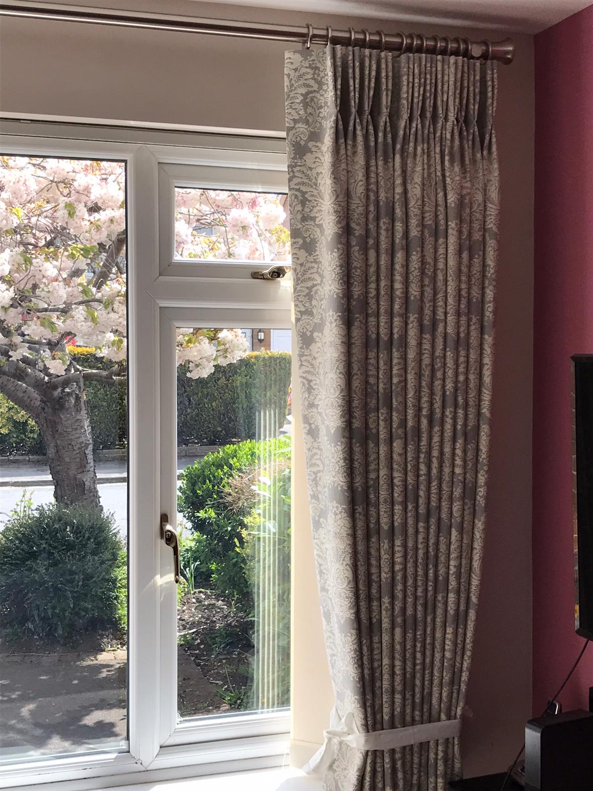 A living room with a large window and curtains on it.