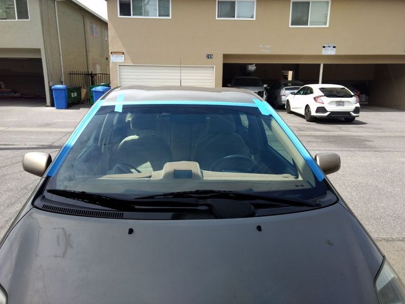 A car with blue tape on the windshield