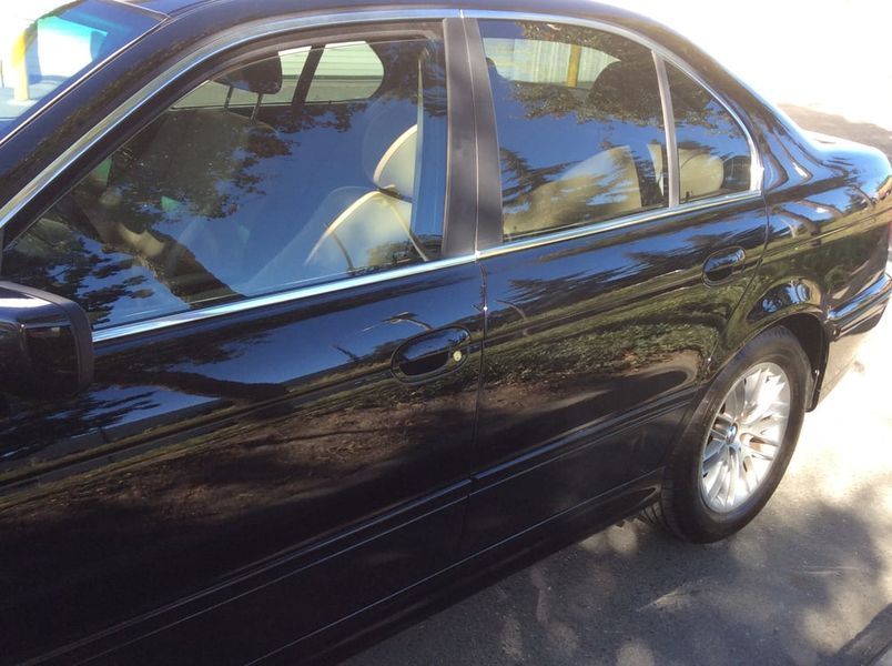 Black sedan parked outdoors with tinted windows