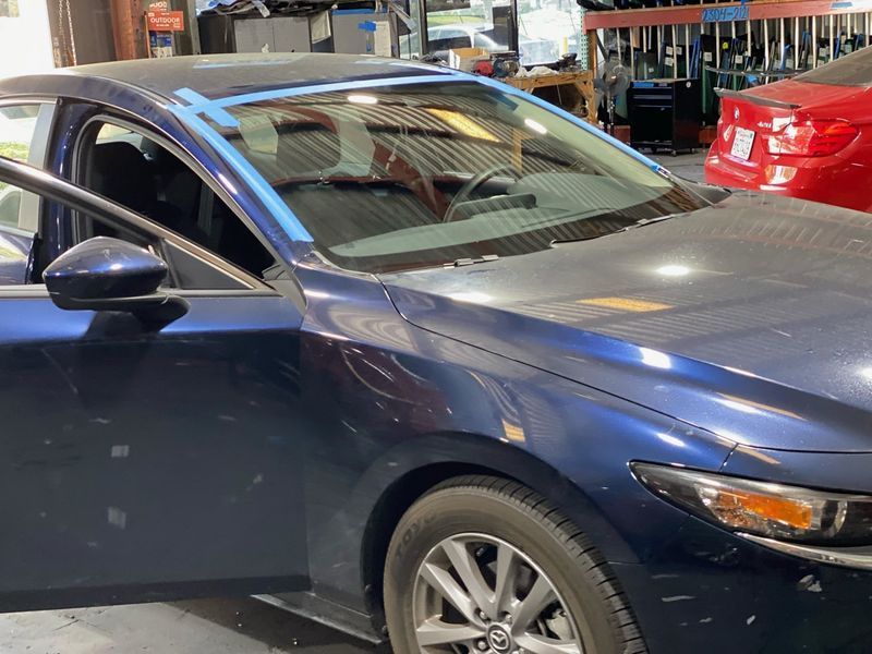 Blue car with an open door in a repair shop
