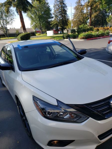 White nissan altima with tinted windshield