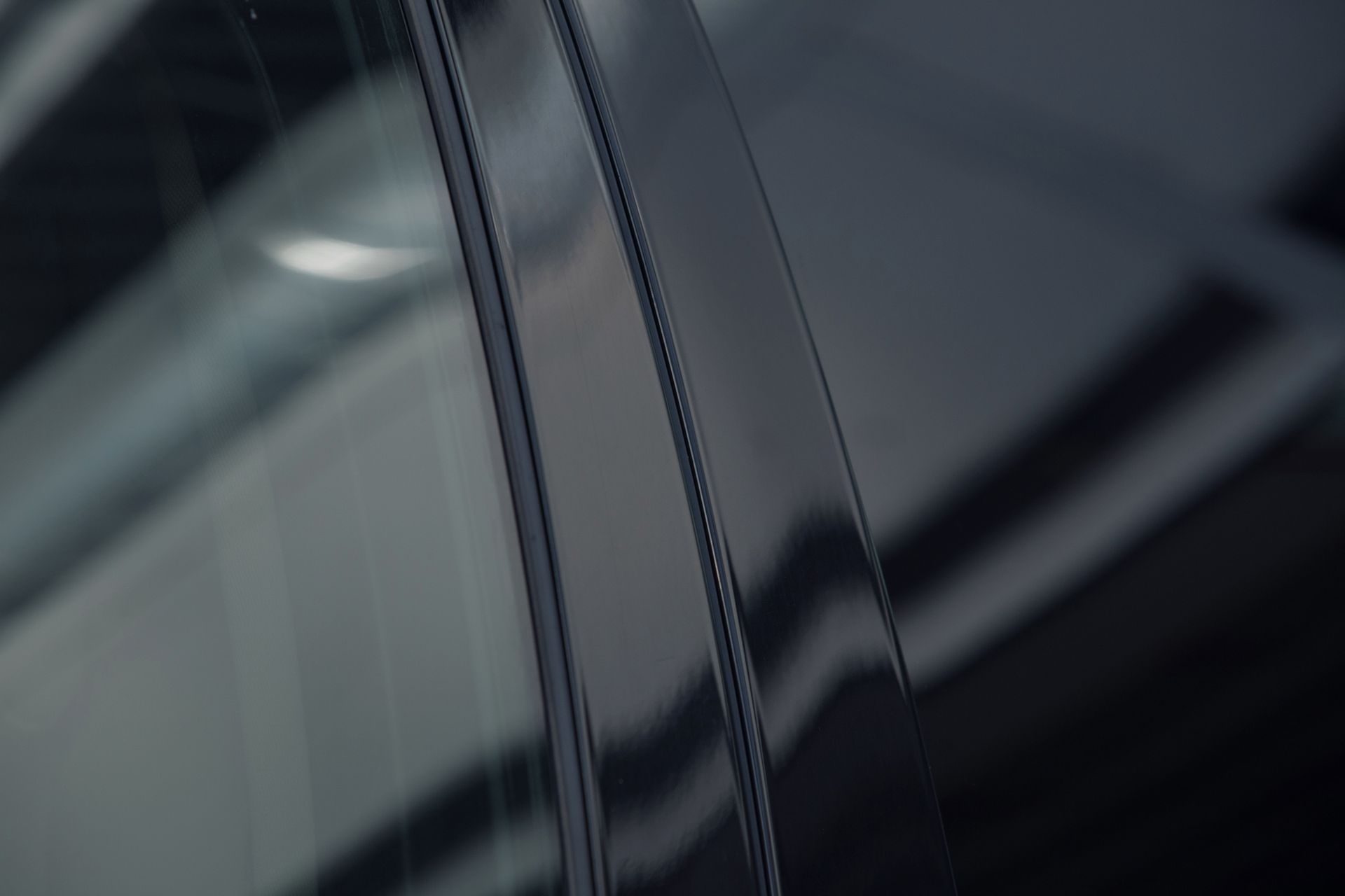Close-up of a shiny black car window frame 