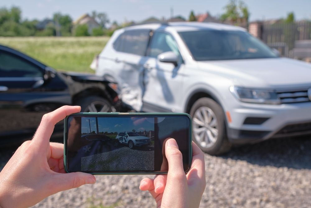 A Person is Taking a Picture of a Car Accident With a Cell Phone — Panel Pro Smash Repairs in Wodonga, VIC