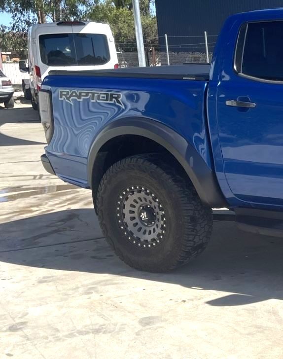 Blue Ford Raptor truck with black wheels and fender flares. It's parked outside on a sunny day  — Panel Pro Smash Repairs in Wodonga, VIC