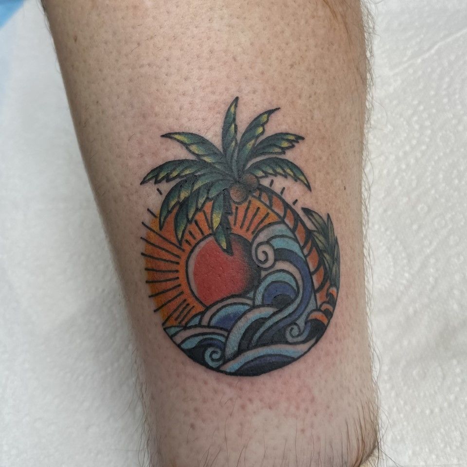 Tattoo of a tropical scene, sun, waves, and palm tree. — Whitsunday Tattooing Airlie Beach in Whitsundays, QLD