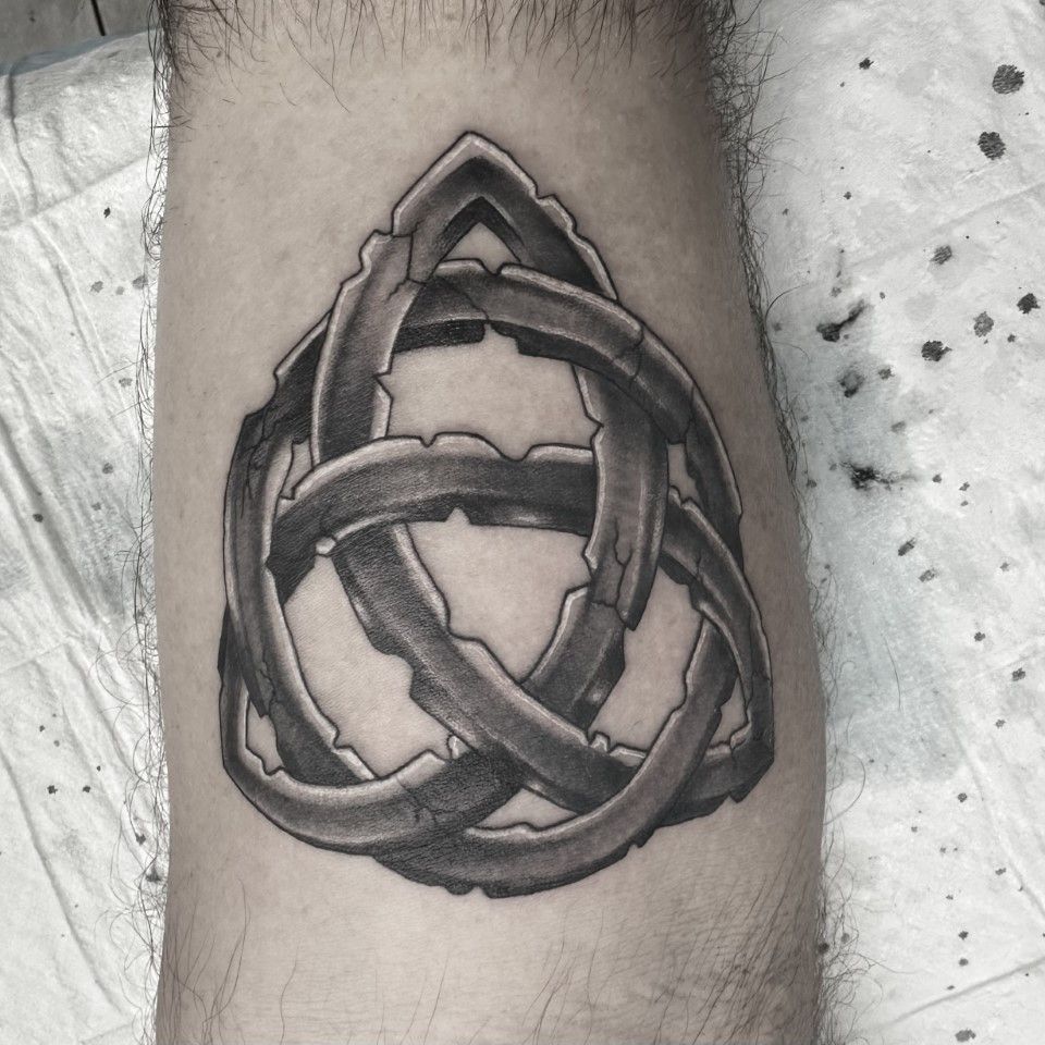 Black and gray Celtic knot tattoo on an arm, showing interwoven lines with a rough texture. — Whitsunday Tattooing Airlie Beach in Whitsundays, QLD