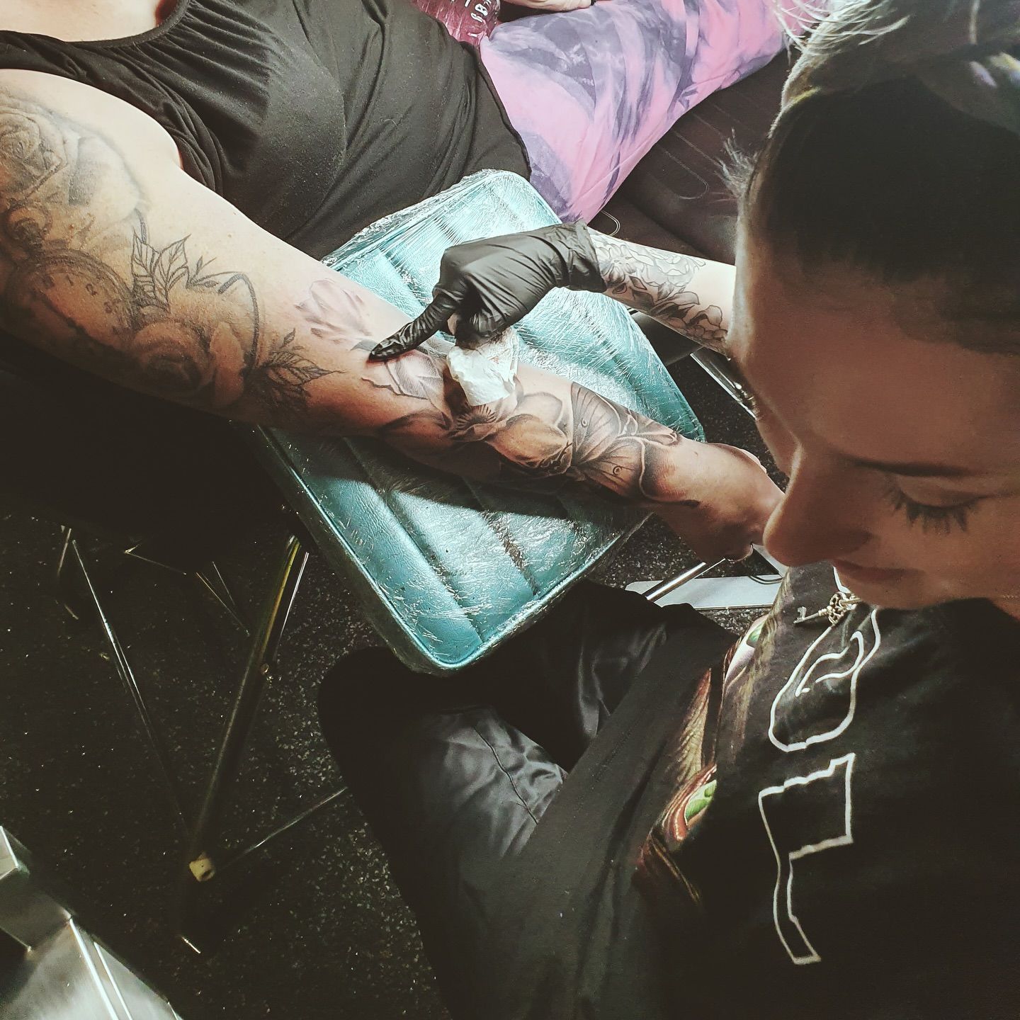 Tattoo Artist Wearing Black Gloves Working on a Client's Arm — Whitsunday Tattooing Airlie Beach in Airlie Beach, QLD