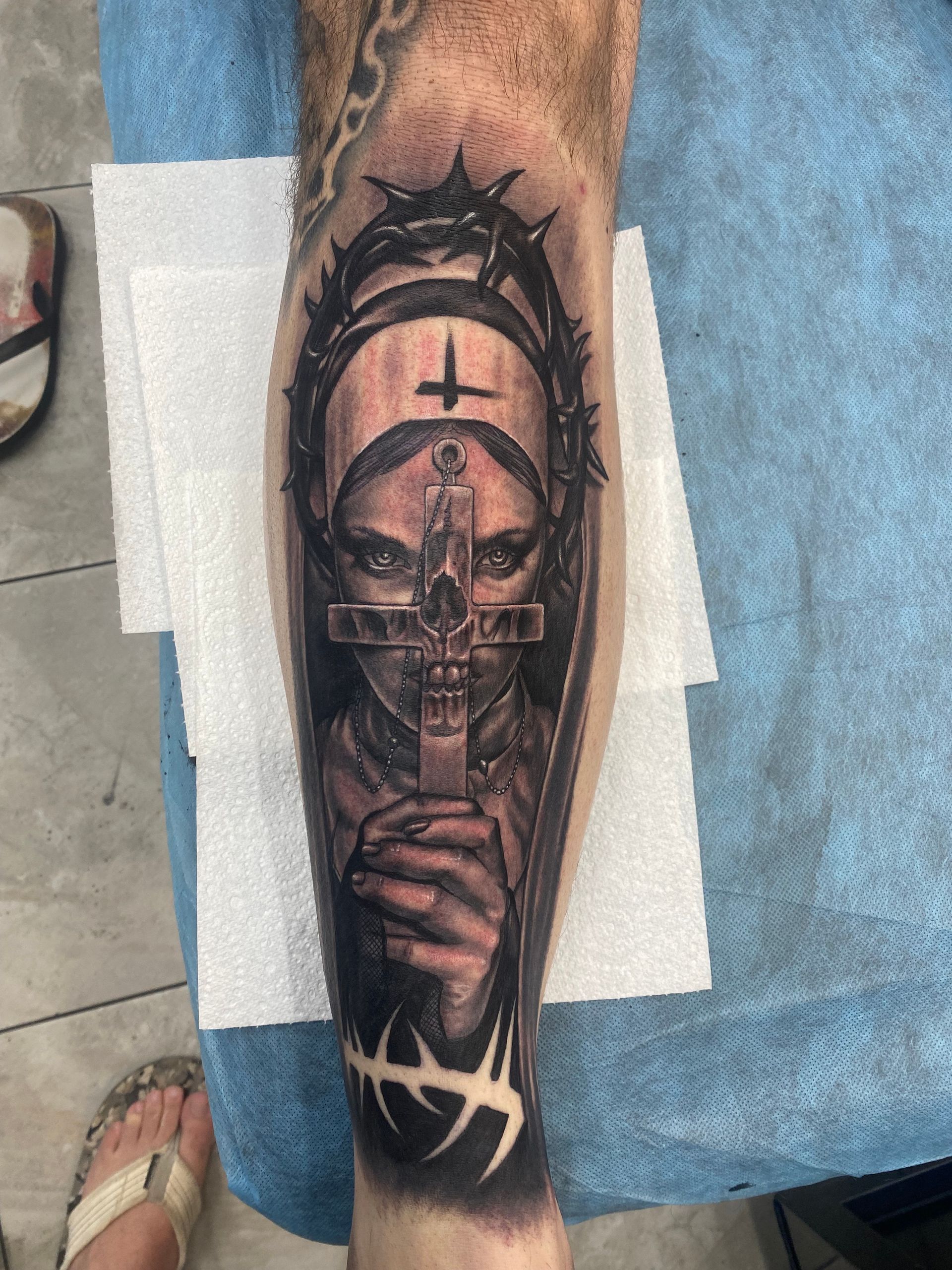 Tattoo of a nun holding a cross, wearing a crown of thorns on a leg. Black and gray ink. — Whitsunday Tattooing Airlie Beach in Whitsundays, QLD