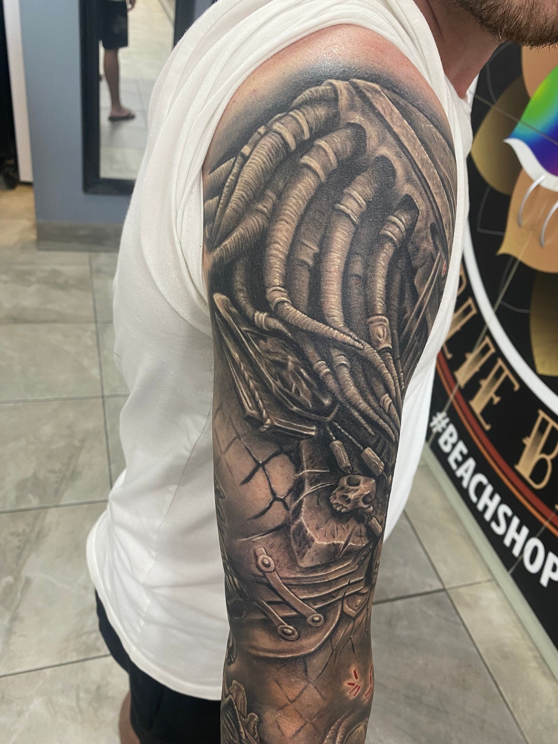 Tattoo of a Predator character on a person's arm, rendered in gray and black tones. — Whitsunday Tattooing Airlie Beach in Whitsundays, QLD