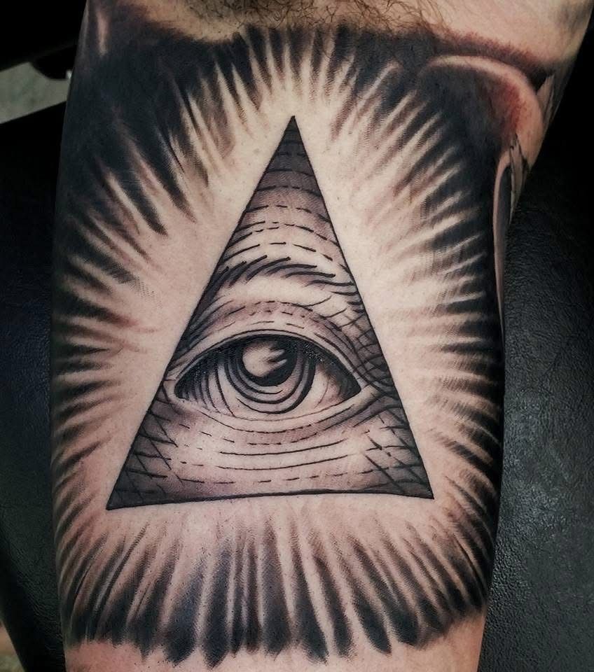 Tattoo of an eye within a triangle, surrounded by radiating lines on an arm. — Whitsunday Tattooing Airlie Beach in Whitsundays, QLD