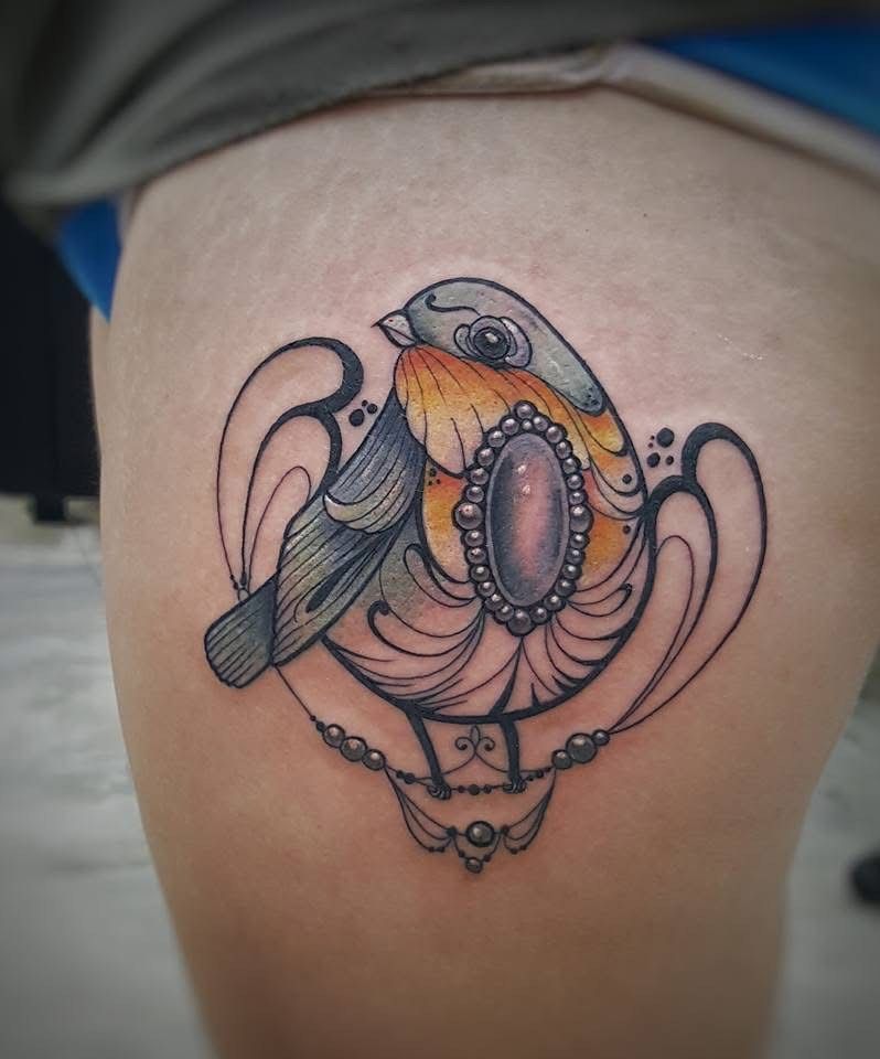 Tattoo of a robin bird with orange chest, surrounded by an ornate frame and jewel on thigh. — Whitsunday Tattooing Airlie Beach in Whitsundays, QLD