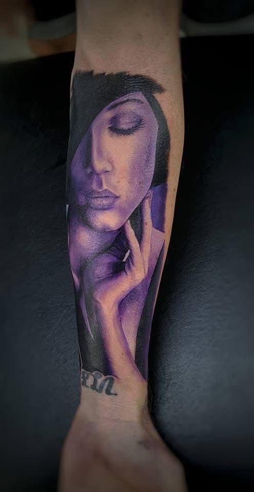 Purple portrait tattoo of a woman on an arm, with eyes closed and hand near face. — Whitsunday Tattooing Airlie Beach in Whitsundays, QLD
