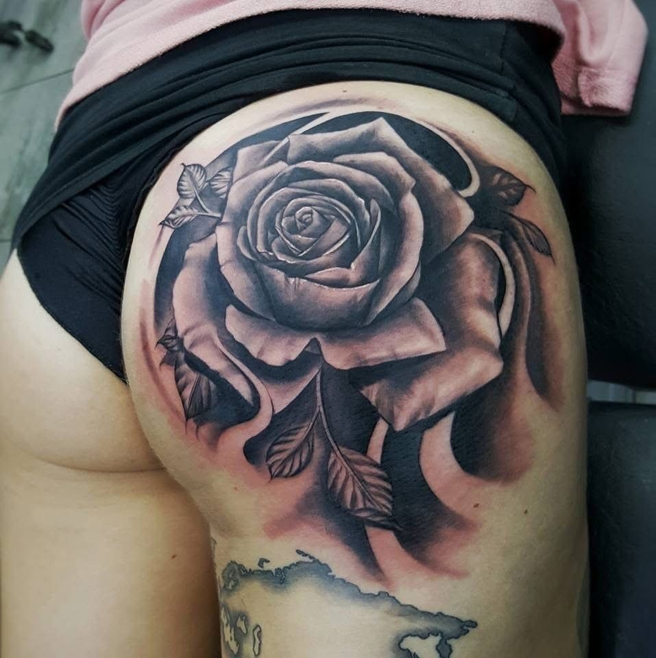 Black and gray rose tattoo on a person's buttock, surrounded by shading. — Whitsunday Tattooing Airlie Beach in Whitsundays, QLD