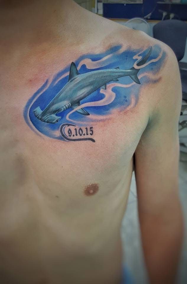 Hammerhead shark tattoo on a chest, surrounded by blue water and white waves. Date: 0.10.15. — Whitsunday Tattooing Airlie Beach in Whitsundays, QLD