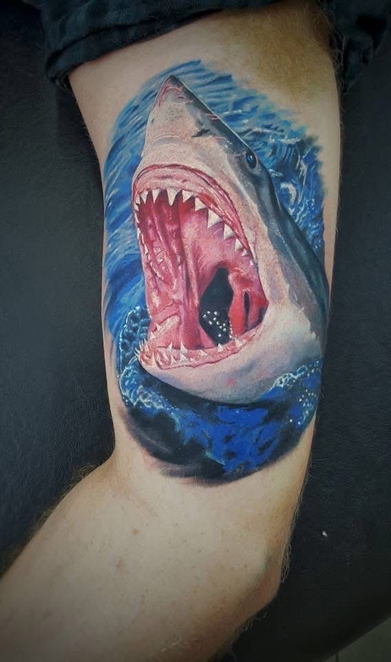 Shark tattoo on an arm, open mouth with sharp teeth in blue ocean waves. — Whitsunday Tattooing Airlie Beach in Whitsundays, QLD