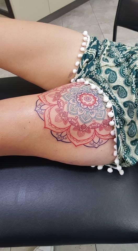 Mandala tattoo on a person's thigh, red, pink, and grey with paisley shorts. — Whitsunday Tattooing Airlie Beach in Whitsundays, QLD