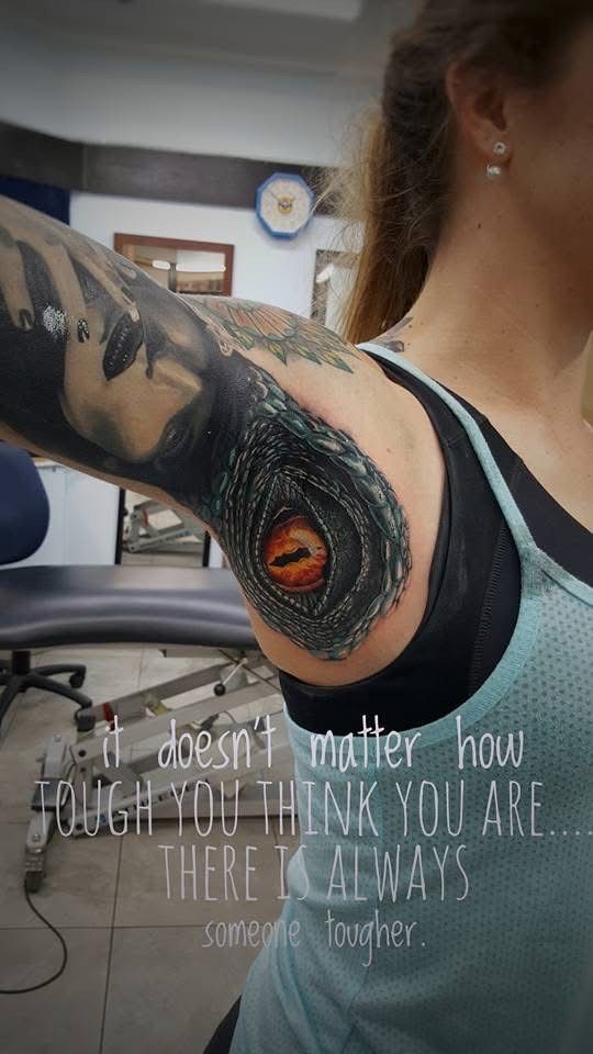Woman with a dragon eye tattoo on her shoulder with text: “It doesn't matter how tough you think you are... There is always someone tougher.” — Whitsunday Tattooing Airlie Beach in Whitsundays, QLD