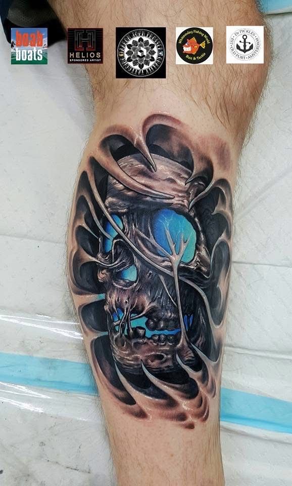 Calf tattoo: skull with blue glowing eyes in a ripped skin effect. — Whitsunday Tattooing Airlie Beach in Whitsundays, QLD