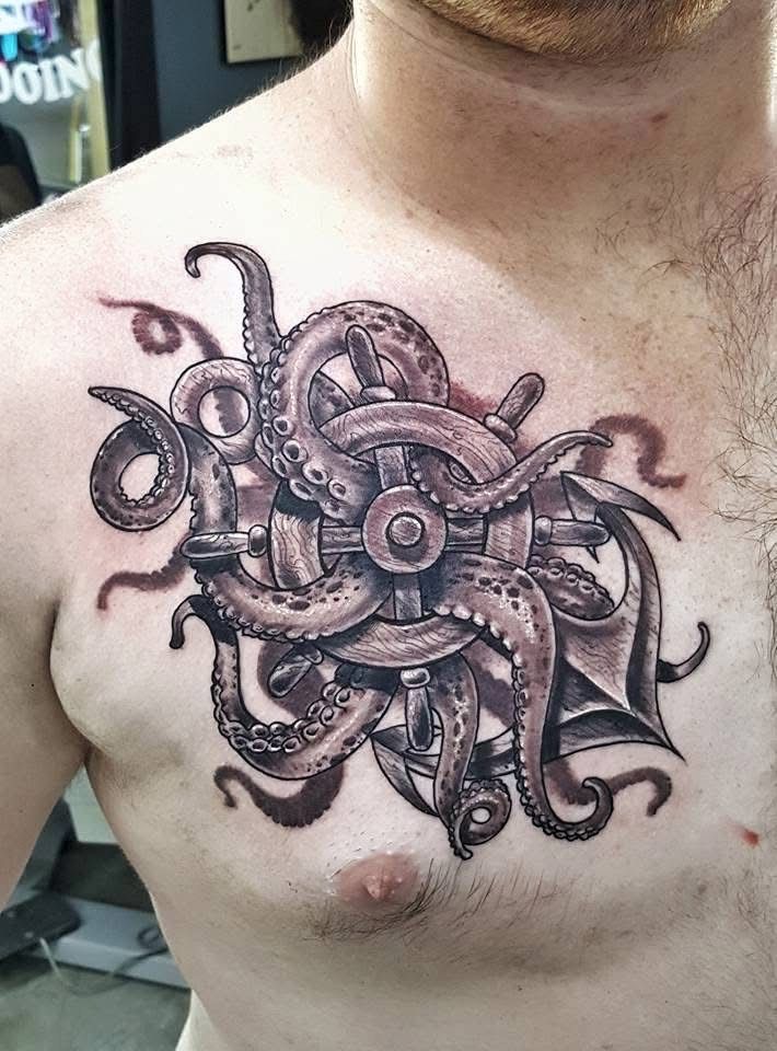 Tattoo of an octopus entwined around a ship's wheel and anchor on a chest. Brown and black ink. — Whitsunday Tattooing Airlie Beach in Whitsundays, QLD