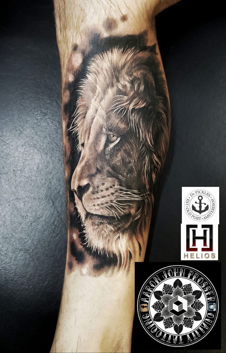 Lion tattoo on a leg, with detailed shading and depth. Logos are visible below the tattoo. — Whitsunday Tattooing Airlie Beach in Whitsundays, QLD