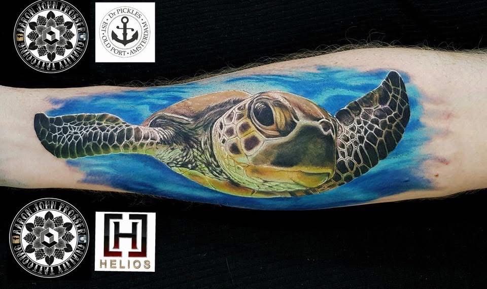 Realistic sea turtle tattoo on forearm, surrounded by blue water. — Whitsunday Tattooing Airlie Beach in Whitsundays, QLD