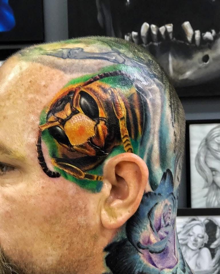 Head tattoo of a detailed wasp on a bald head, green and yellow tones. — Whitsunday Tattooing Airlie Beach in Whitsundays, QLD