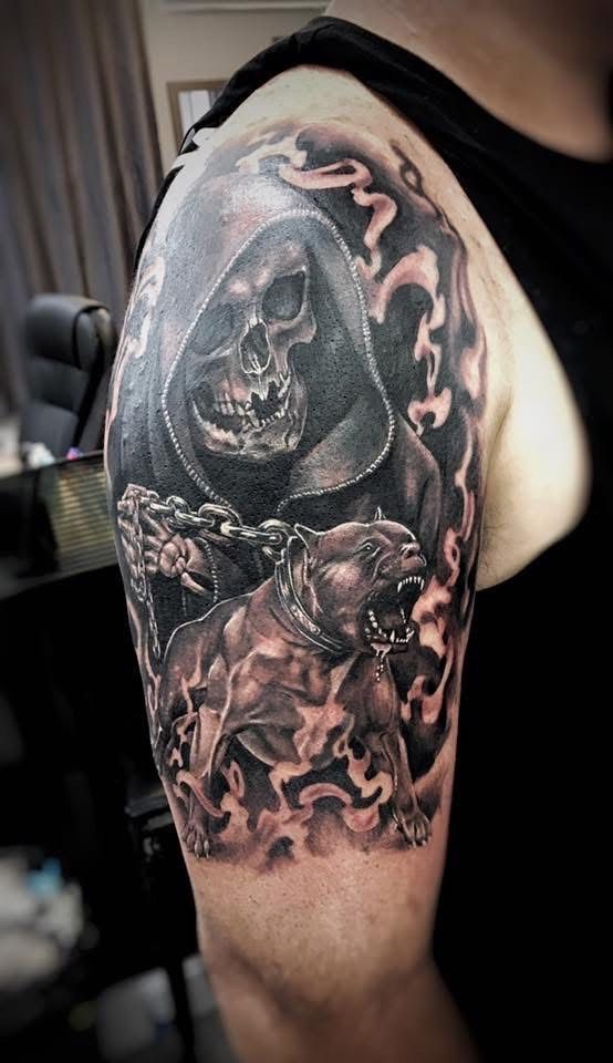 Tattoo on arm depicting the Grim Reaper holding chains, with a snarling dog in smoke. — Whitsunday Tattooing Airlie Beach in Whitsundays, QLD