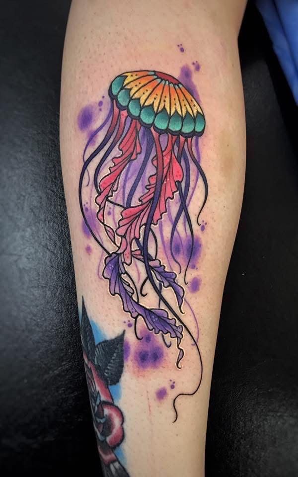 Jellyfish tattoo on leg; purple, pink, orange, green, and black ink. — Whitsunday Tattooing Airlie Beach in Whitsundays, QLD