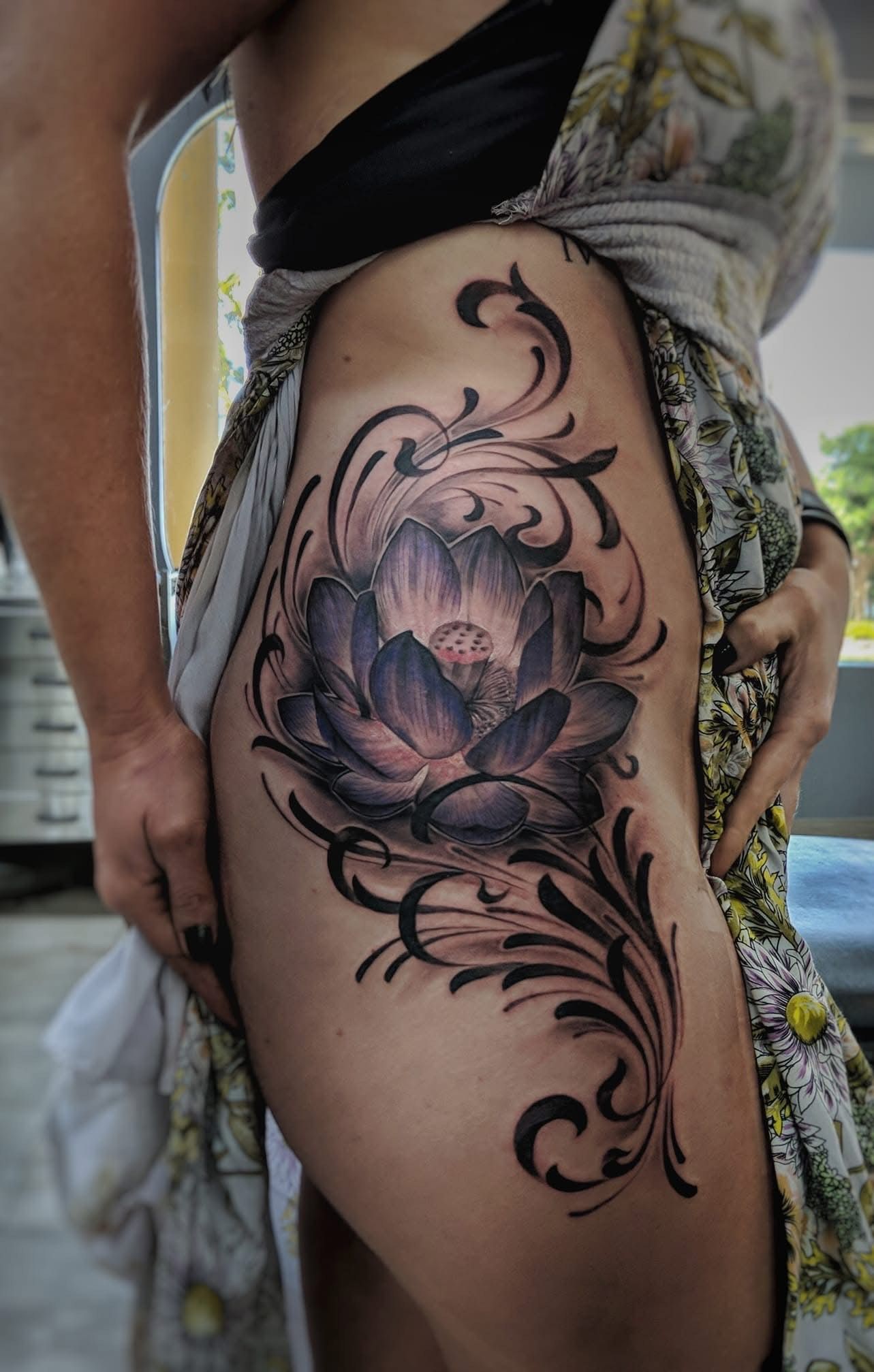 Tattoo of a black and gray lotus flower and swirling designs on a person's side. — Whitsunday Tattooing Airlie Beach in Whitsundays, QLD