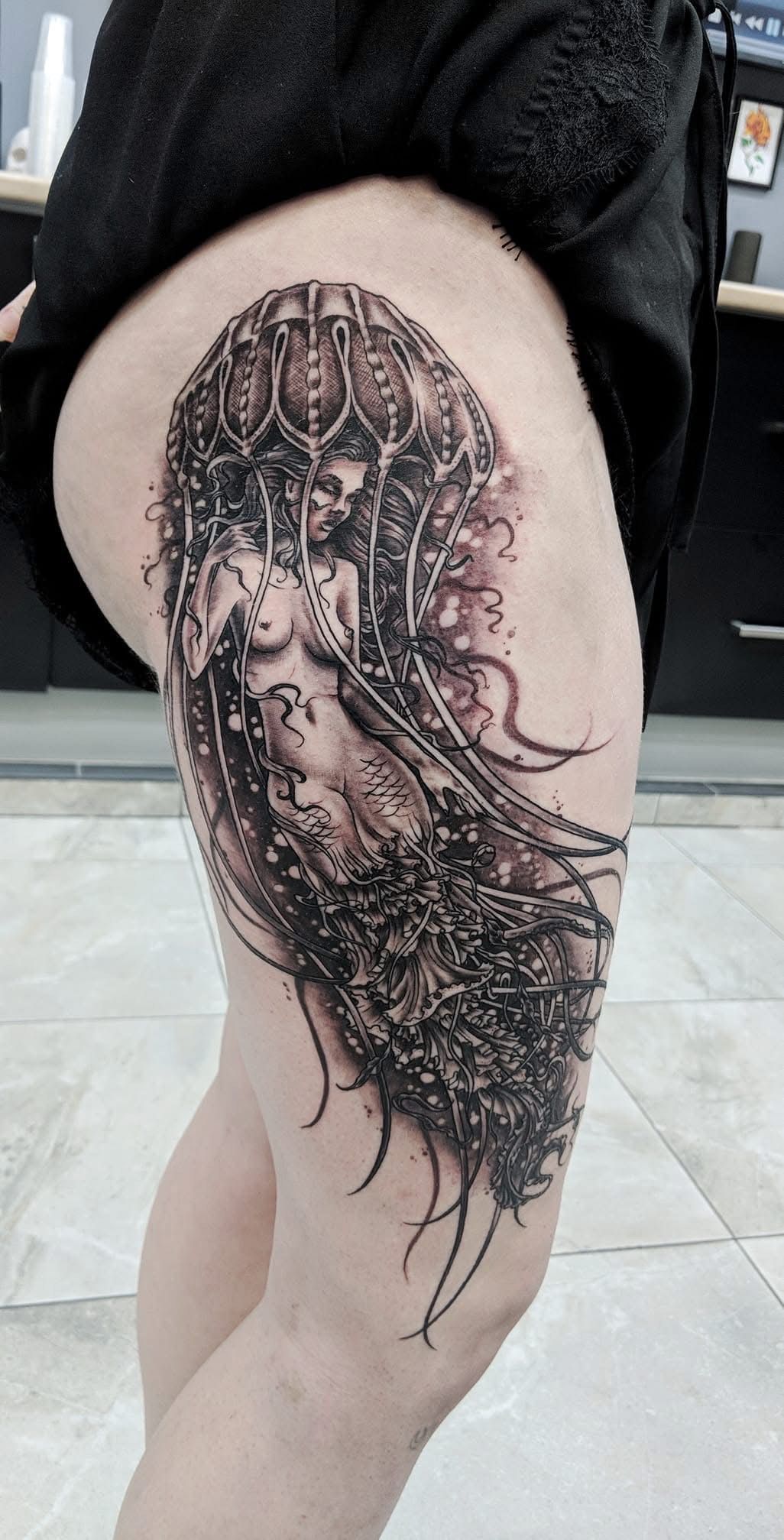 Tattoo of a woman's face and intricate design on the thigh. Black ink with fine detail. — Whitsunday Tattooing Airlie Beach in Whitsundays, QLD