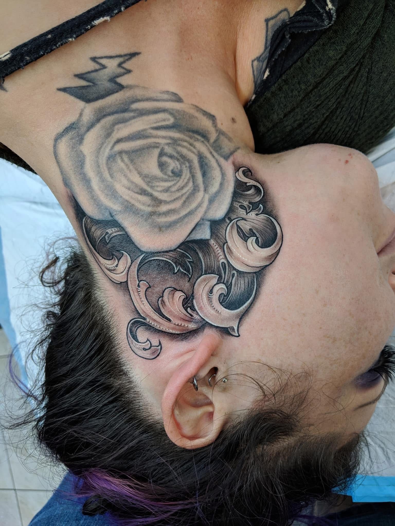 Tattoo of a rose and ornate design on a person's neck. Dark hair and beard are visible. — Whitsunday Tattooing Airlie Beach in Whitsundays, QLD