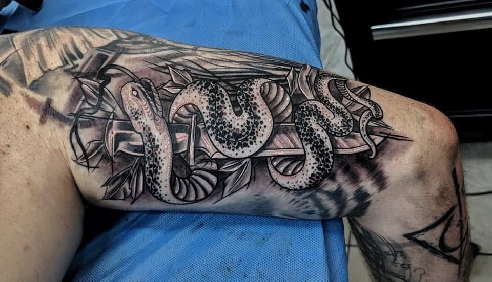 Tattoo on leg: snake coiled around a wooden structure, black and gray shading. — Whitsunday Tattooing Airlie Beach in Whitsundays, QLD