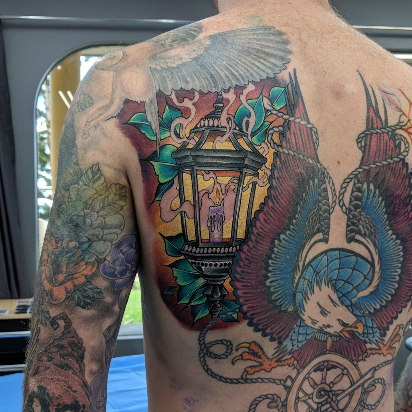 Back Tattoo of a Lantern, Eagle, and Other Designs — Whitsunday Tattooing Airlie Beach in Airlie Beach, QLD