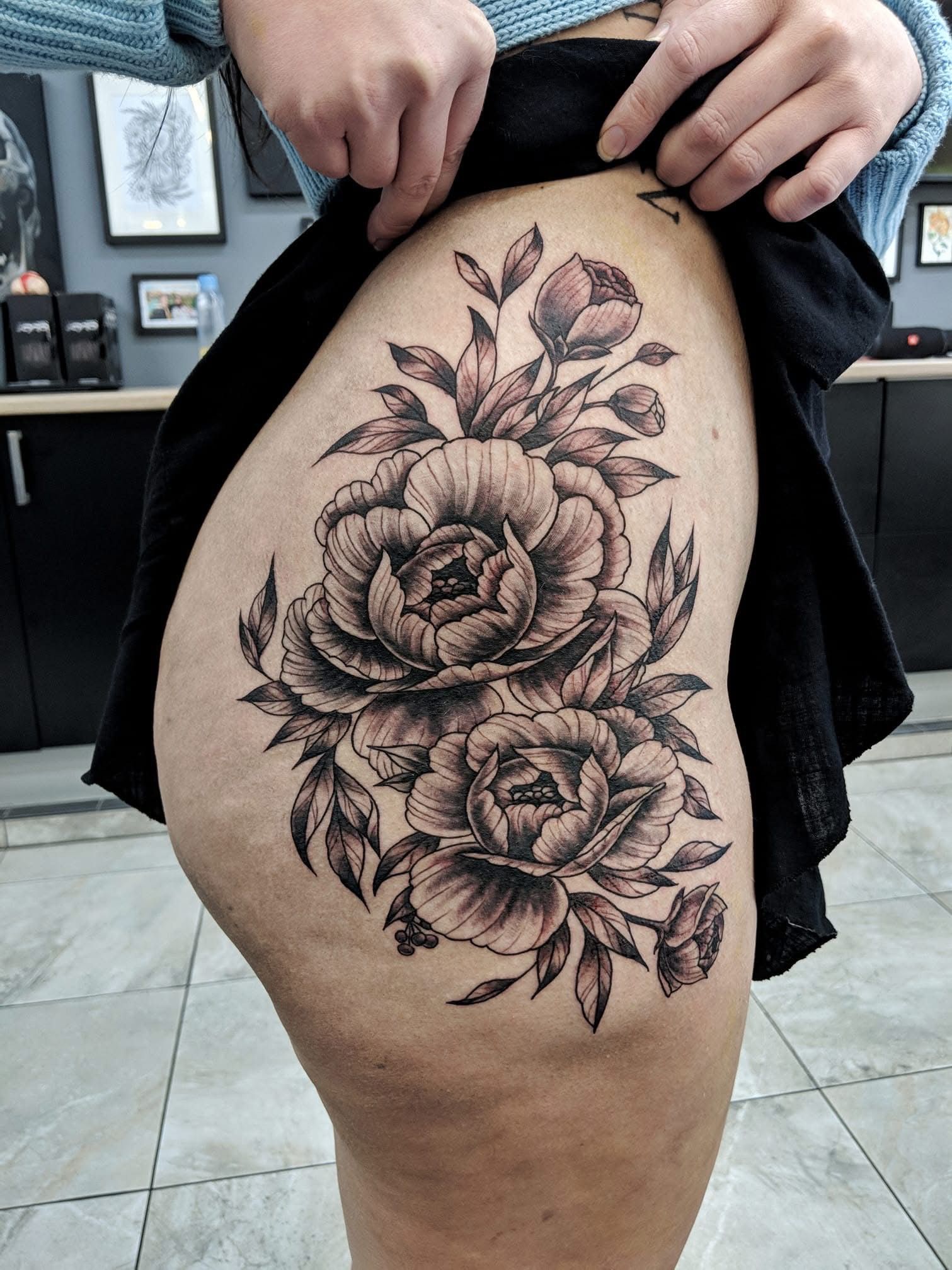 Black and gray peony tattoo on a person's thigh. — Whitsunday Tattooing Airlie Beach in Whitsundays, QLD