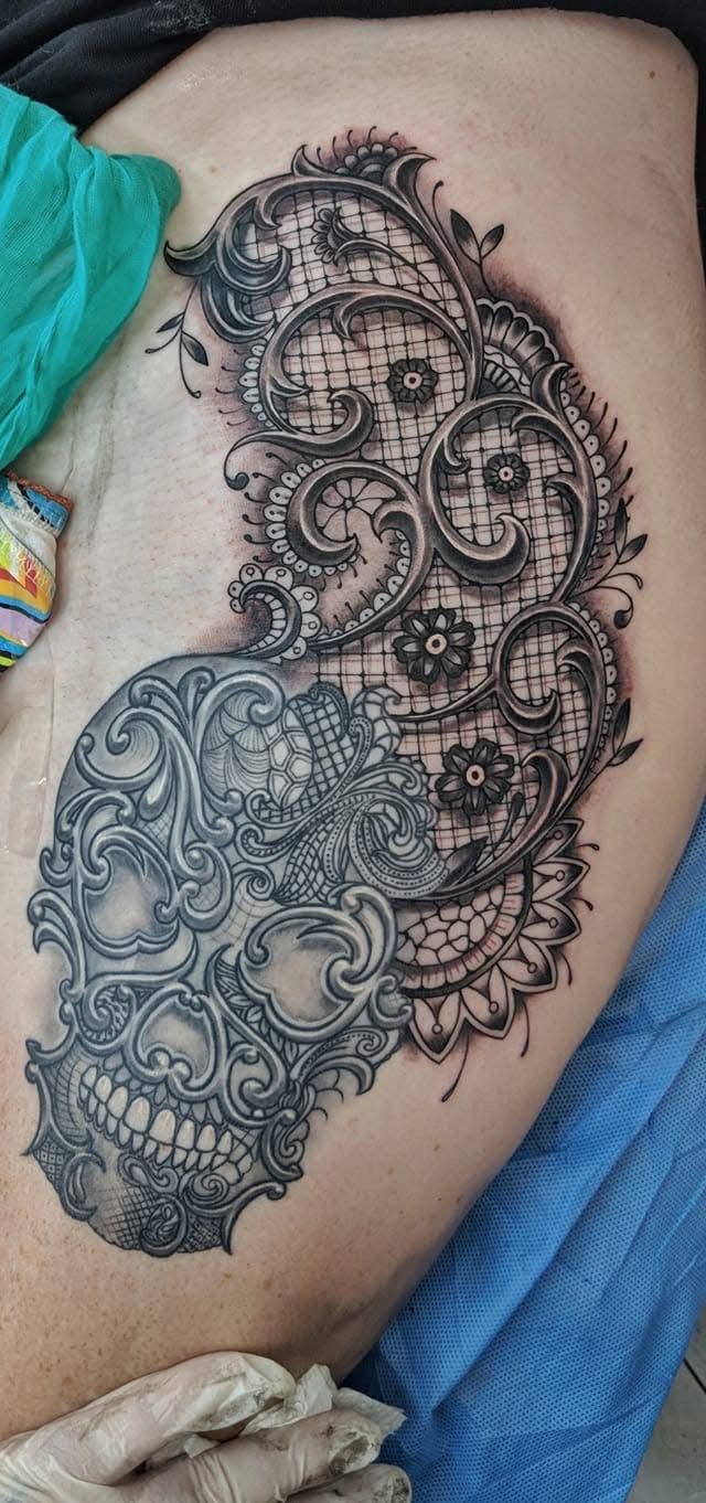 Tattoo of a sugar skull design with intricate lace details on a person's thigh. — Whitsunday Tattooing Airlie Beach in Whitsundays, QLD