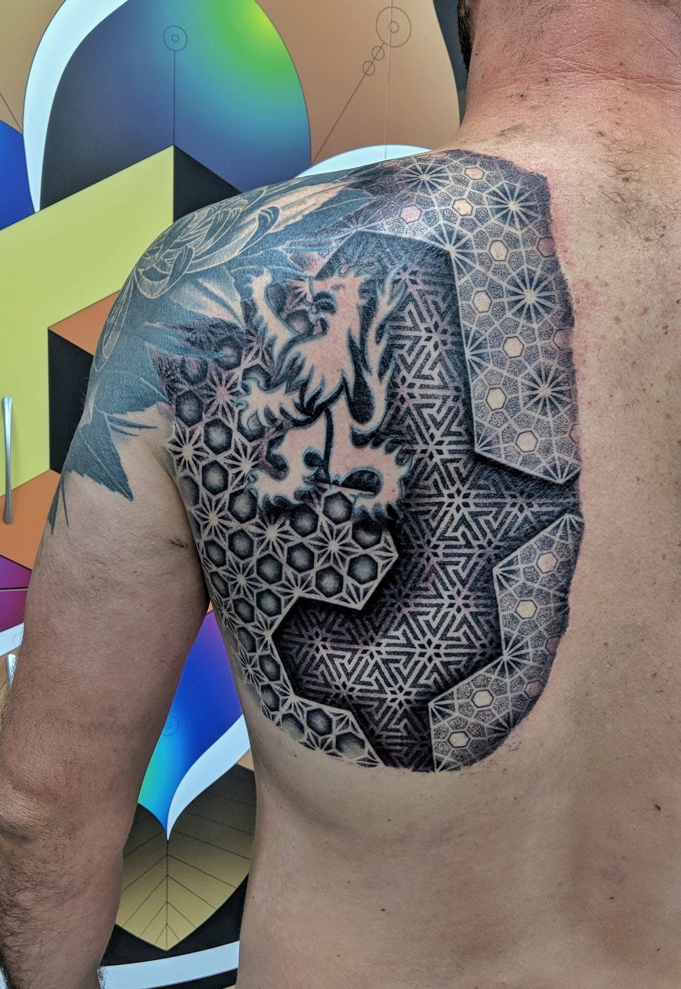 Tattoo on a person's shoulder and back featuring a lion, geometric shapes, and various patterns. — Whitsunday Tattooing Airlie Beach in Whitsundays, QLD