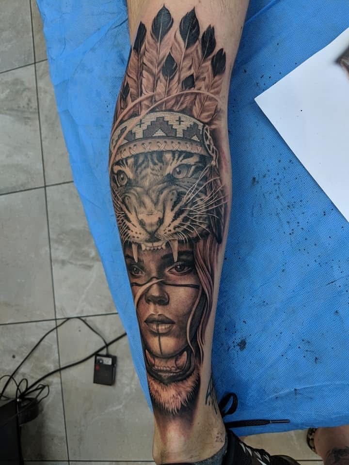 Tattoo on calf: Native American woman with tiger headdress and feathers, in black and gray ink. — Whitsunday Tattooing Airlie Beach in Whitsundays, QLD