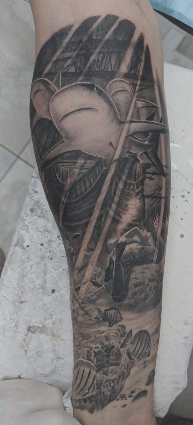 Tattoo of a character with a large head and a warrior-like figure with beams of light, on an arm. — Whitsunday Tattooing Airlie Beach in Whitsundays, QLD