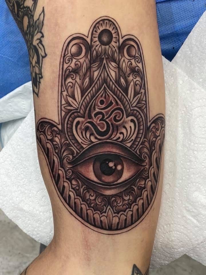Tattoo of a Hamsa hand with an eye and the Om symbol. The detailed design is in black and gray ink. — Whitsunday Tattooing Airlie Beach in Whitsundays, QLD