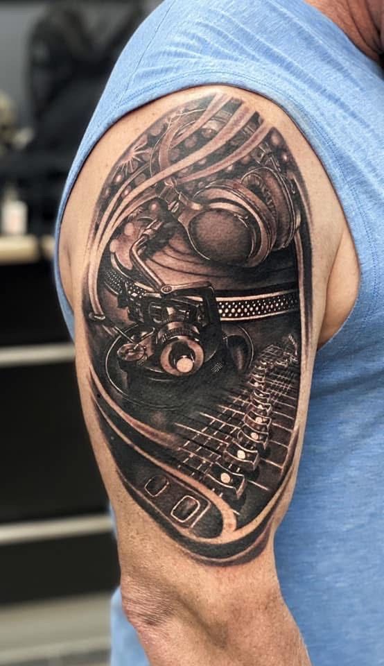 Tattoo of a sound system on a person's upper arm. Features a record player, headphones, and soundboard. — Whitsunday Tattooing Airlie Beach in Whitsundays, QLD