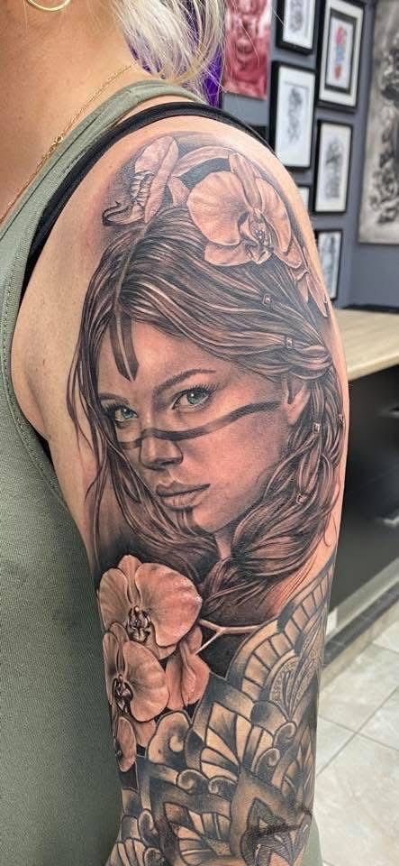 Tattoo of a woman's face with orchid flowers and tribal markings. — Whitsunday Tattooing Airlie Beach in Whitsundays, QLD