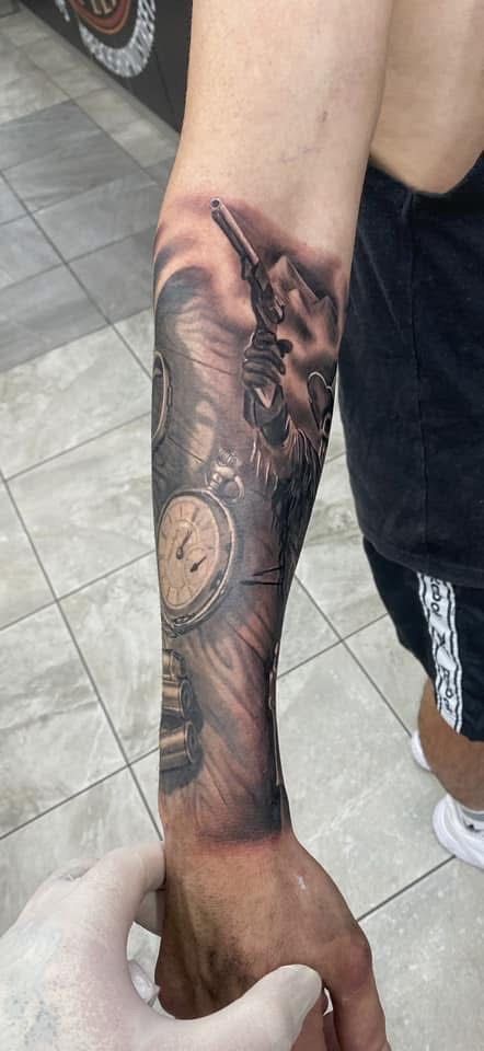 Arm with a detailed black and gray tattoo featuring a pocket watch and gears. — Whitsunday Tattooing Airlie Beach in Whitsundays, QLD