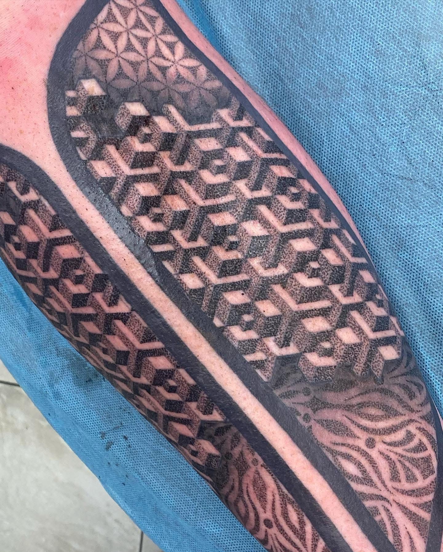 Tattoo on arm with geometric shapes, including cubes and floral designs, in shades of black. — Whitsunday Tattooing Airlie Beach in Whitsundays, QLD