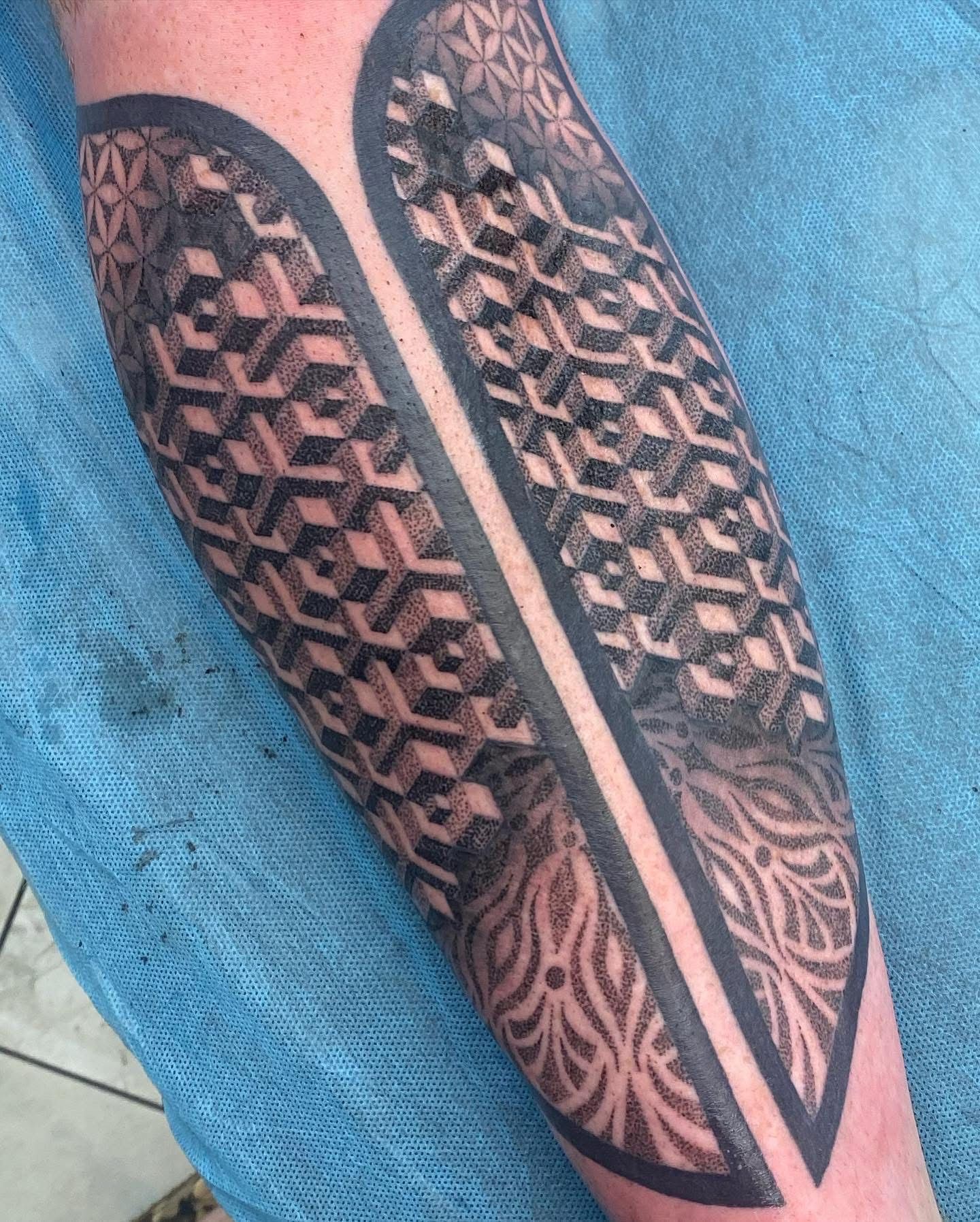 Tattoo on forearm, geometric black design with symmetrical patterns and vertical black borders. — Whitsunday Tattooing Airlie Beach in Whitsundays, QLD
