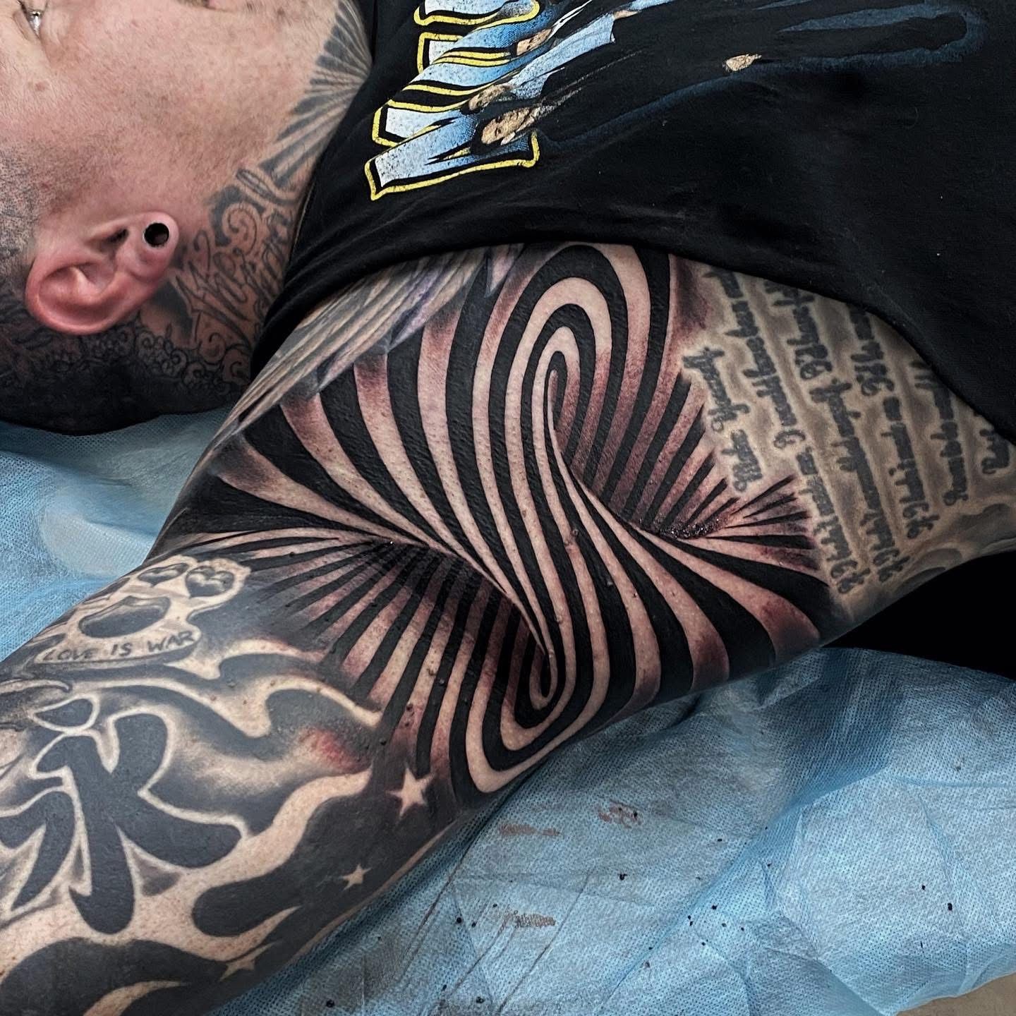 Tattoo of an optical illusion in black and gray, on a person's arm and torso, with text and other designs visible. — Whitsunday Tattooing Airlie Beach in Whitsundays, QLD
