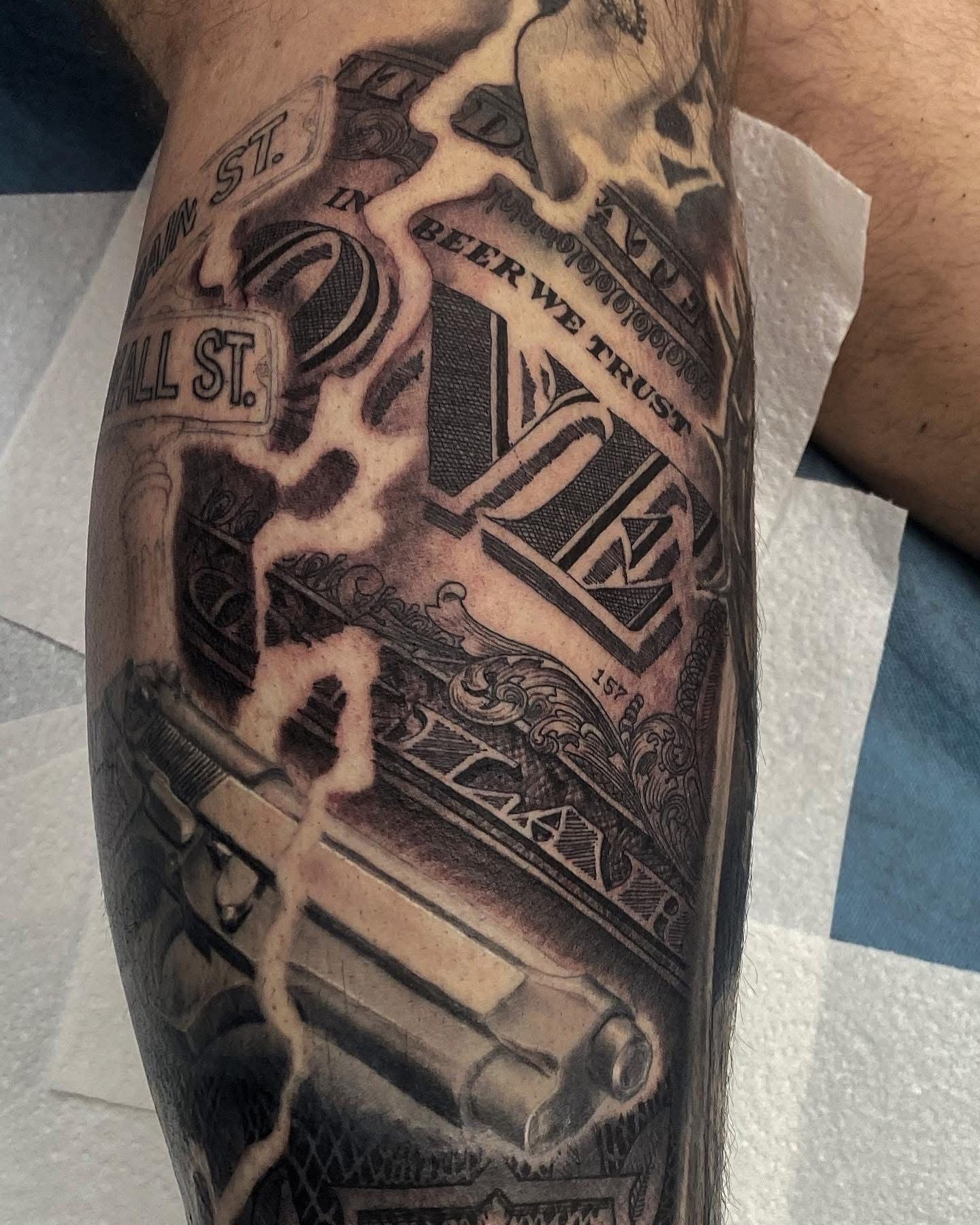 Tattoo on a leg featuring a pistol,