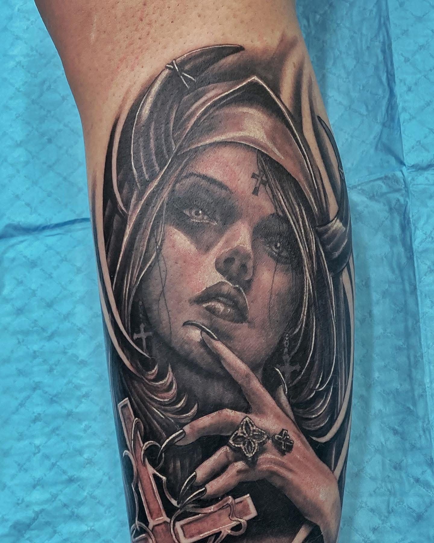 Tattoo of a woman in a hooded cloak, finger to lips, holding a gun and cross. Black and gray shading. — Whitsunday Tattooing Airlie Beach in Whitsundays, QLD